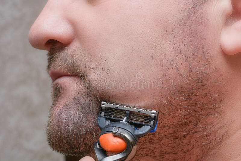 Homme avec des chaumes sur la joue. rase la barbe avec le rasoir. concept de soins du visage masculin photographie stock