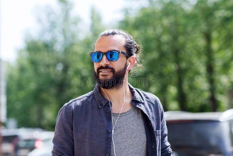 Homme avec des écouteurs écoutant la musique dans la ville photos stock Homme avec des écouteurs écoutant la musique dans la ville photos stock