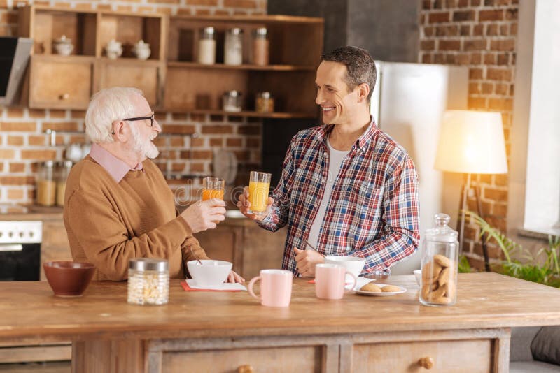 Homme avec du charme et son jus potable de père plus âgé images stock Homme avec du charme et son jus potable de père plus âgé images stock