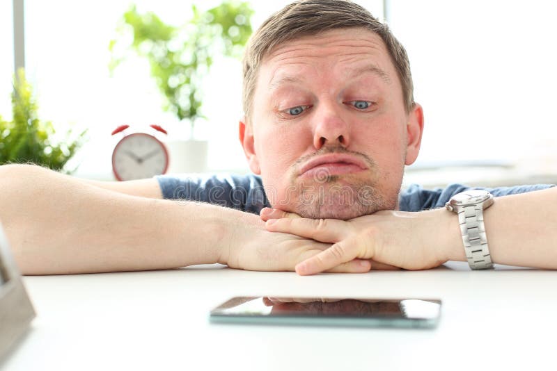 Homme avec l'expression du visage drôle regardant fixement le téléphone portable image libre de droits Homme avec l'expression du visage drôle regardant fixement le téléphone portable image libre de droits