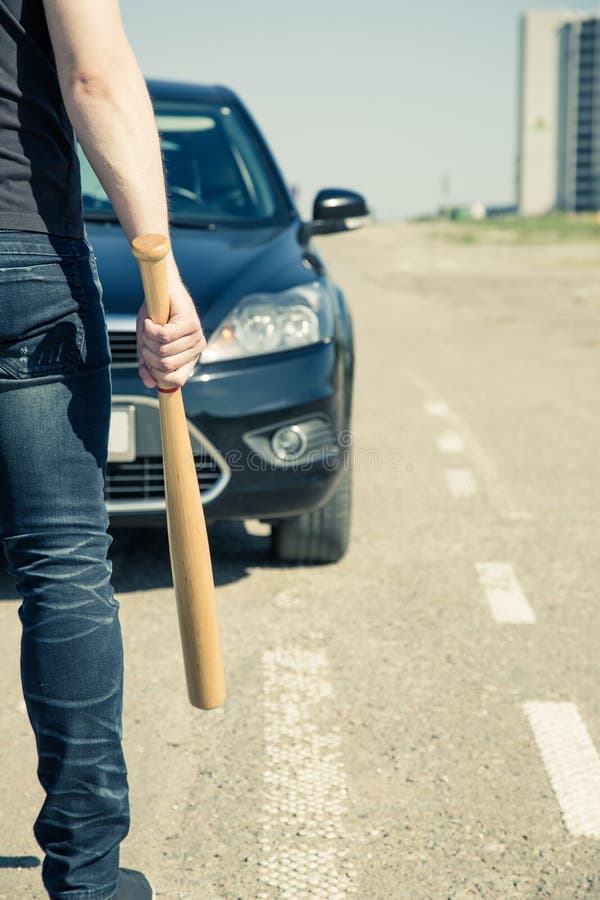 Homme avec la batte de baseball sur la route images libres de droits Homme avec la batte de baseball sur la route images libres de droits