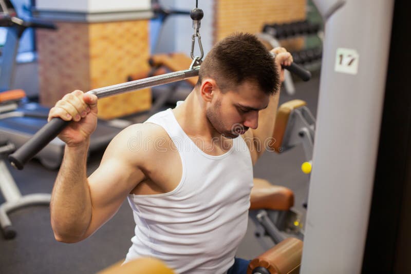 Homme avec la formation de poids dans le club de sport d'équipement de gymnase photo libre de droits Homme avec la formation de poids dans le club de sport d'équipement de gymnase photo libre de droits