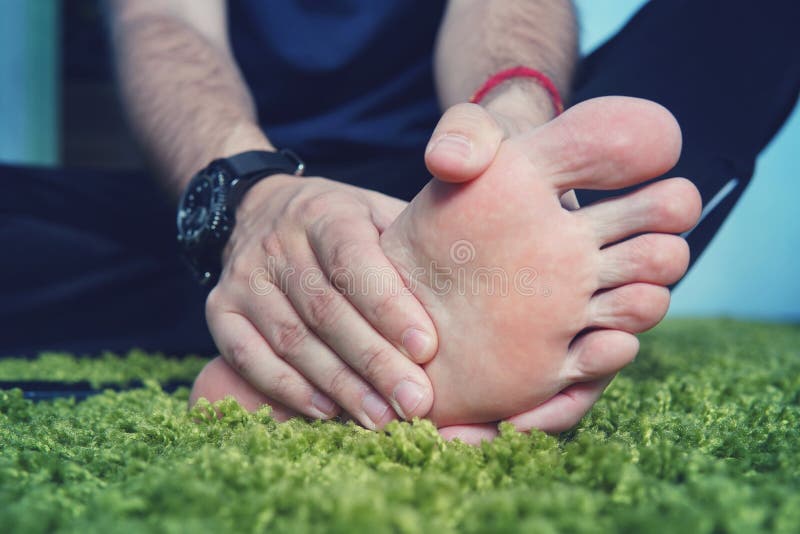 Homme avec la goutte douloureuse et enflammée sur son pied autour du secteur de gros orteil images libres de droits Homme avec la goutte douloureuse et enflammée sur son pied autour du secteur de gros orteil images libres de droits