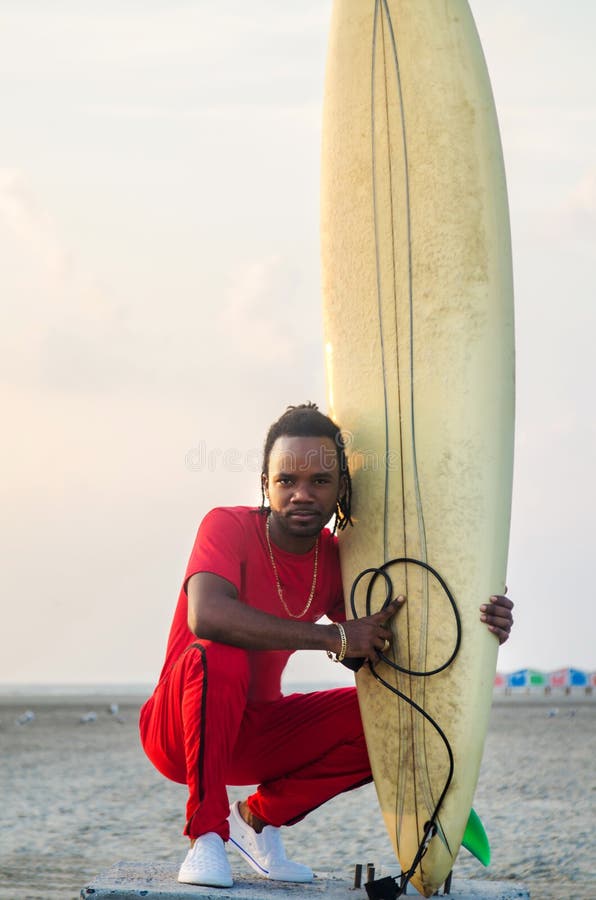 Homme avec la planche de surf sur la plage photos stock Homme avec la planche de surf sur la plage photos stock