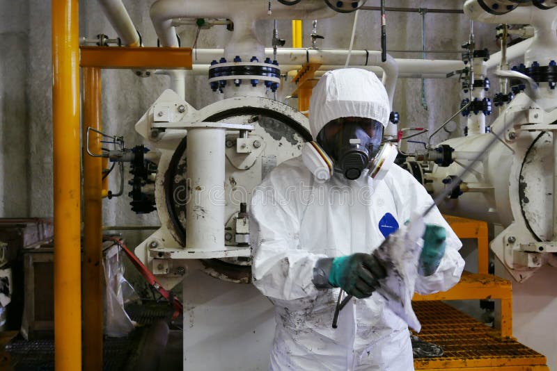 Man with protective mask and chemical protective clothes in danger area. Worker change the filter at oil and gas platform. Man with protective mask and chemical protective clothes in danger area. Worker change the filter at oil and gas platform