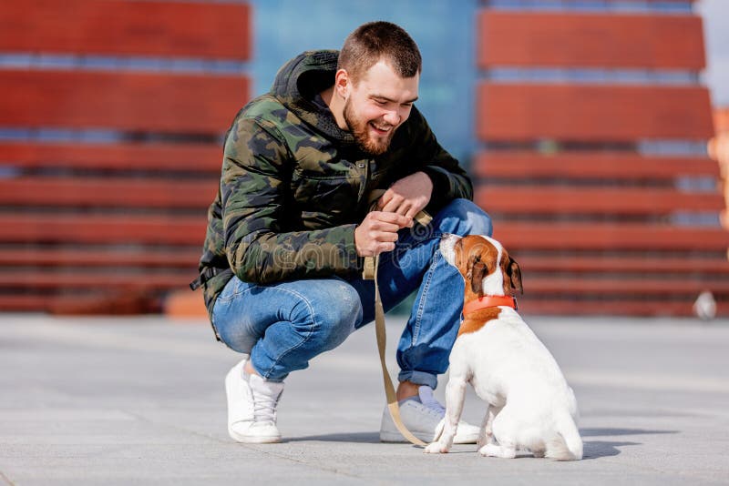 Homme avec son chien, Jack Russell Terrier, sur la rue de ville photo stock Homme avec son chien, Jack Russell Terrier, sur la rue de ville photo stock