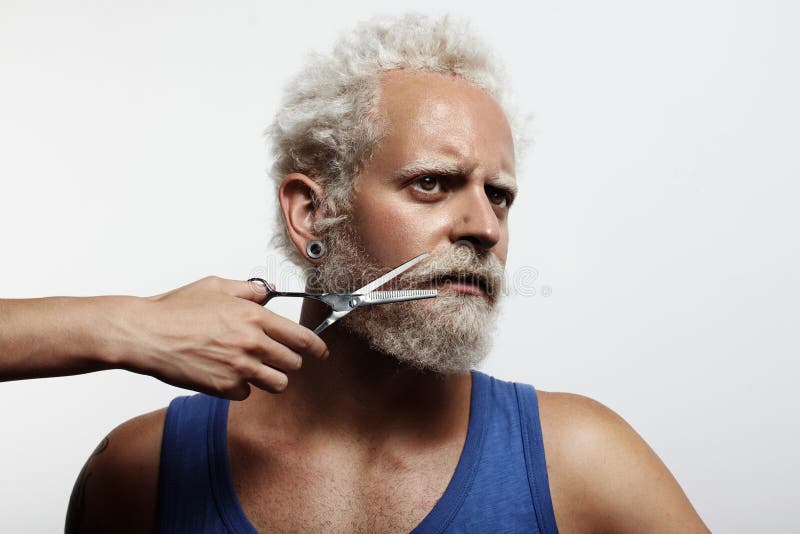 Homme avec une main du ` s de femme, coupant sa barbe image libre de droits Homme avec une main du ` s de femme, coupant sa barbe image libre de droits