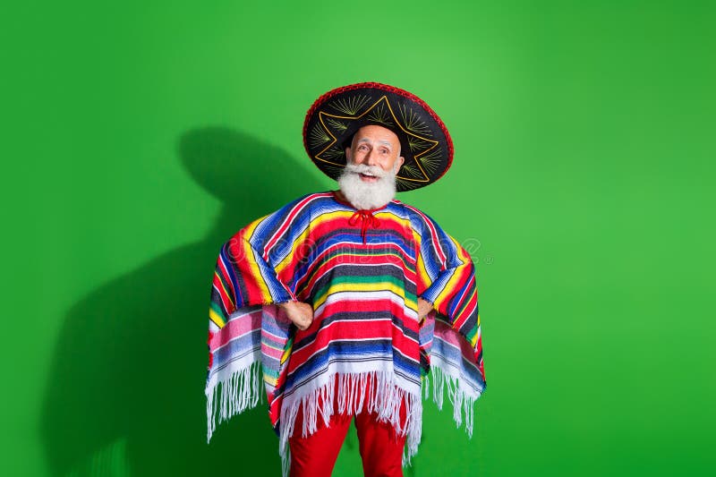 Homme aîné festif en tenue traditionnelle mexicaine célébrant sur fond vert vif photographie stock