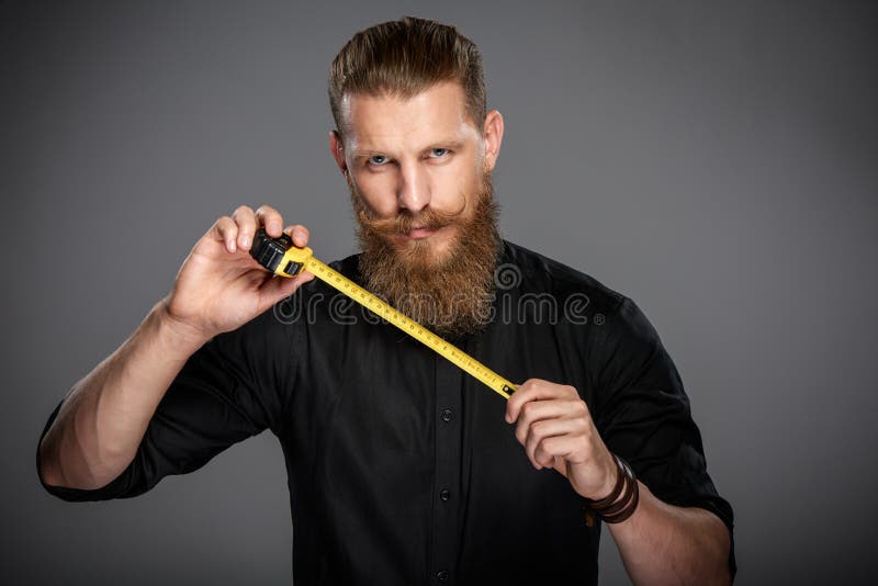 Homme barbu avec la bande de mesure photos stock Homme barbu avec la bande de mesure photos stock