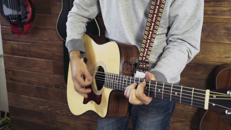 Homme barbu bel jouant le mouvement lent de guitare acoustique