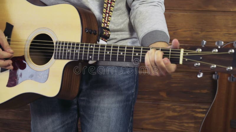 Homme barbu bel jouant le mouvement lent de guitare acoustique