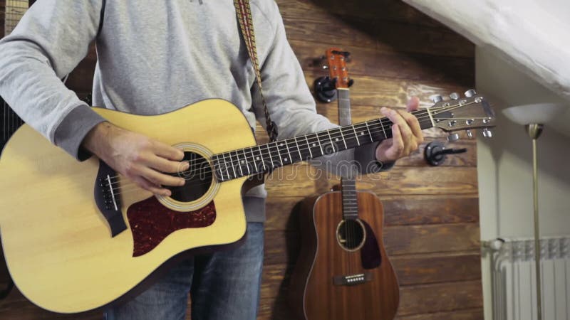 Homme barbu bel jouant le mouvement lent de guitare acoustique