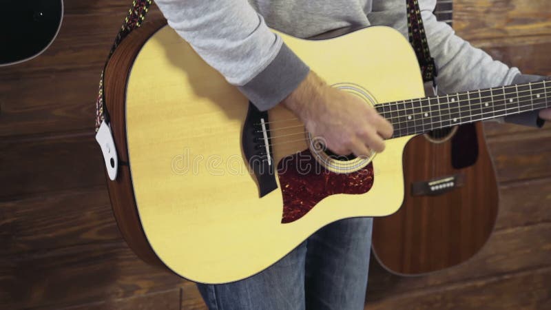 Homme barbu bel jouant le mouvement lent de guitare acoustique