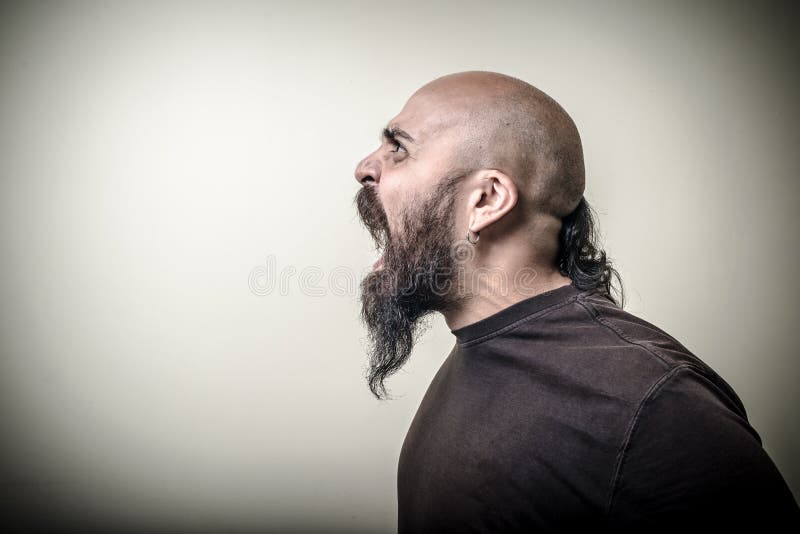 Homme barbu fâché criard de profil photo stock Homme barbu fâché criard de profil photo stock