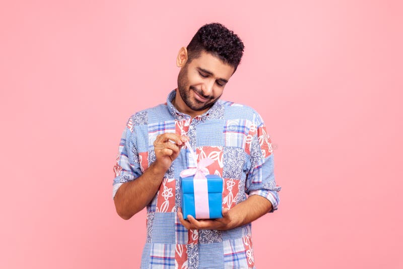 Homme barbu heureux ouvrir boîte cadeau déballer cadeau d'anniversaire cadeau pour célébrer vacances tirant ruban regardant cadeau image libre de droits