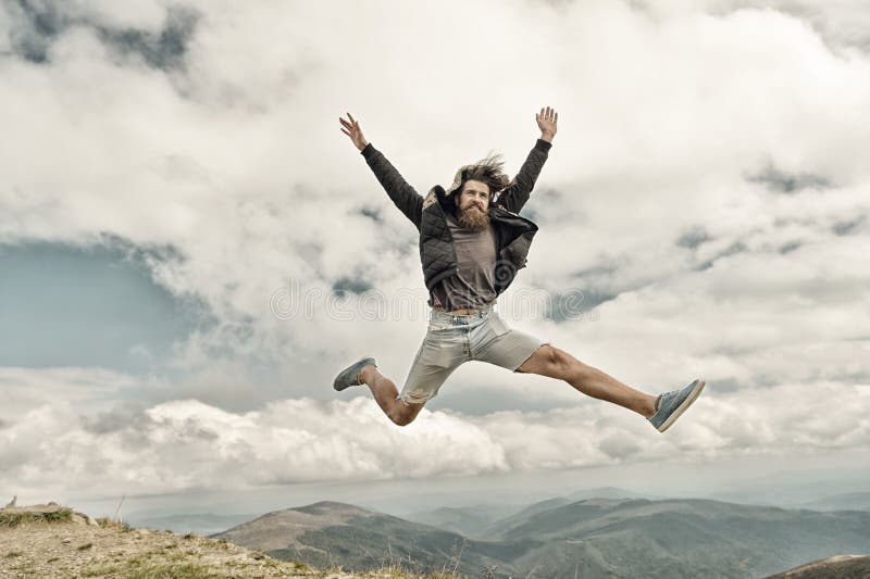 Homme barbu, hippie caucasien brutal avec le saut de moustache sur la montagne images libres de droits Homme barbu, hippie caucasien brutal avec le saut de moustache sur la montagne images libres de droits