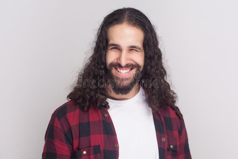 Homme bel drôle avec la barbe et longs cheveux bouclés noirs dans le casua images stock Homme bel drôle avec la barbe et longs cheveux bouclés noirs dans le casua images stock