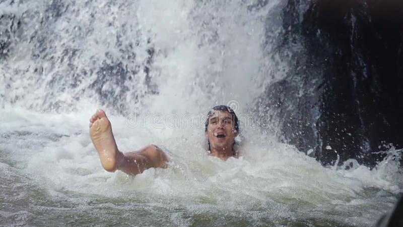 Homme bel heureux détendant sous l'eau de ruisseau en cascade dans la jungle tropicale Mouvement lent 1920x1080, hd