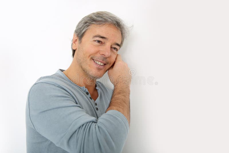 Homme bel mûr se penchant sur le mur photo stock Homme bel mûr se penchant sur le mur photo stock