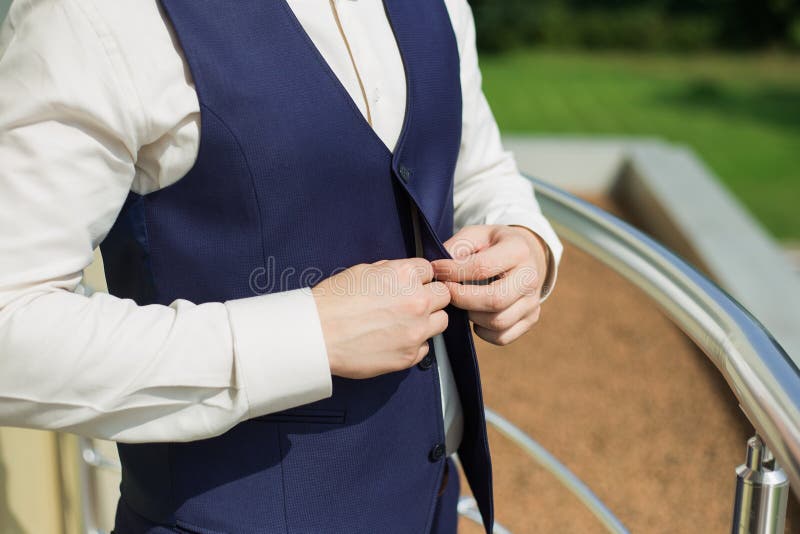 Homme boutonnant le gilet du costume bleu photo stock Homme boutonnant le gilet du costume bleu photo stock