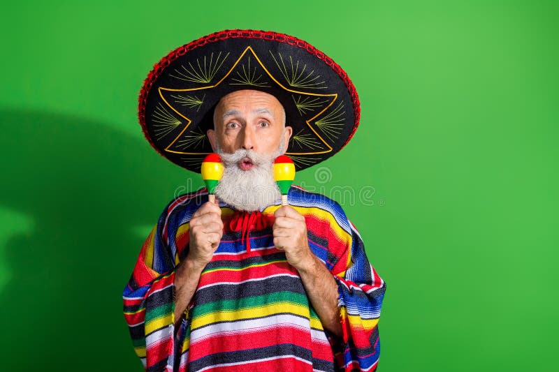 Homme charismatique en tenue traditionnelle mexicaine avec sombrero sur fond vert vif avec des objets colorés image stock