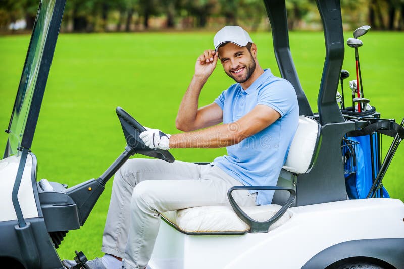 Homme conduisant le chariot de golf images stock Homme conduisant le chariot de golf images stock