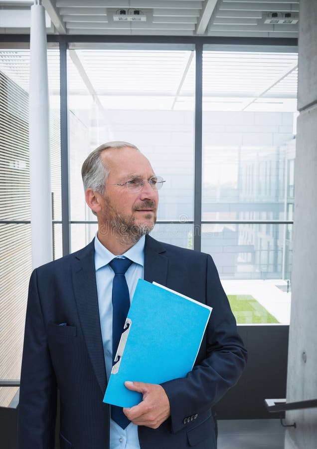 Homme confus d'affaires se tenant sur le fond de bâtiment photo stock Homme confus d'affaires se tenant sur le fond de bâtiment photo stock