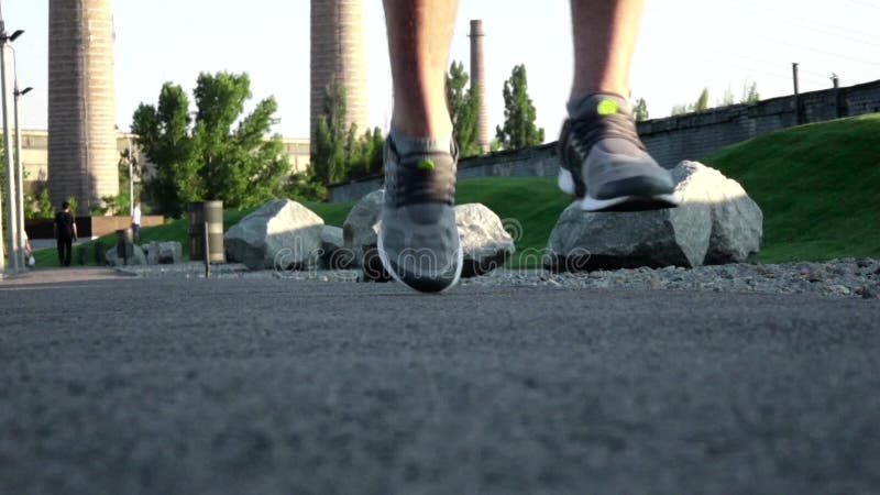 Homme courant pulsant dans la fin de parc des chaussures de chaussures dans l'herbe en parc Fin vers le haut Mouvement lent banque de vidéos