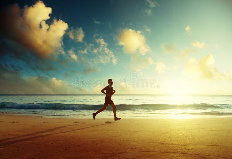 Homme courant sur la plage tropicale au coucher du soleil images stock Homme courant sur la plage tropicale au coucher du soleil images stock