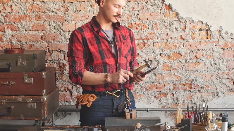 Homme créatif magnifique aplatissant et formant des métaux et des bijoux