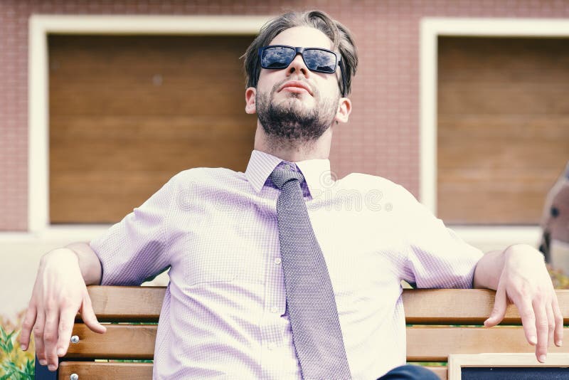 Homme d'affaires adulte recherchant les lunettes de soleil de port sur la rue de ville photo libre de droits Homme d'affaires adulte recherchant les lunettes de soleil de port sur la rue de ville photo libre de droits
