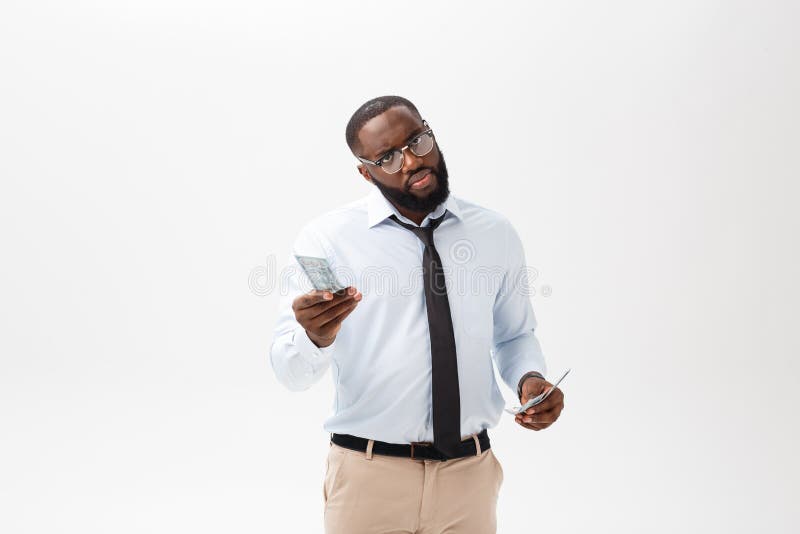 Homme d'affaires d'afro-américain tenant l'argent liquide et la caméra de regard sérieuse D'intérieur, d'isolement sur le fond gr photo libre de droits Homme d'affaires d'afro-américain tenant l'argent liquide et la caméra de regard sérieuse D'intérieur, d'isolement sur le fond gr photo libre de droits