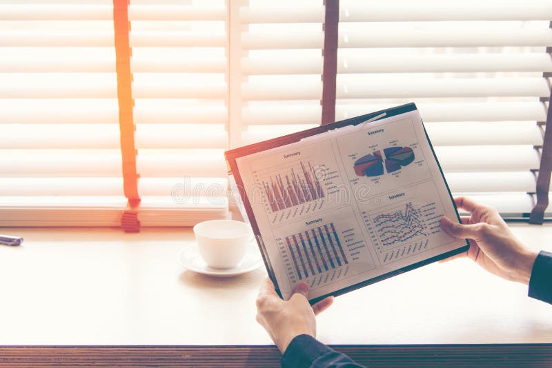 Homme d'affaires analysant des diagrammes d'investissement dans l'espace de travail photos stock Homme d'affaires analysant des diagrammes d'investissement dans l'espace de travail photos stock