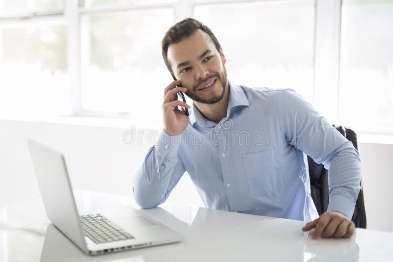 Homme d'affaires attirant mexicain sur son 30s fonctionnant au siège social moderne avec l'ordinateur portable d'ordinateur photographie stock libre de droits Homme d'affaires attirant mexicain sur son 30s fonctionnant au siège social moderne avec l'ordinateur portable d'ordinateur photographie stock libre de droits