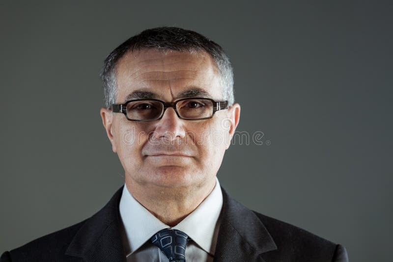 Homme d'affaires d'une cinquantaine d'années attirant en verres images stock Homme d'affaires d'une cinquantaine d'années attirant en verres images stock