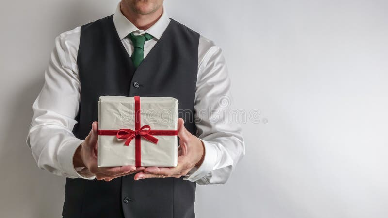 Homme d'affaires dans le gilet de costume tenant un cadeau/présent de Noël photos libres de droits Homme d'affaires dans le gilet de costume tenant un cadeau/présent de Noël photos libres de droits