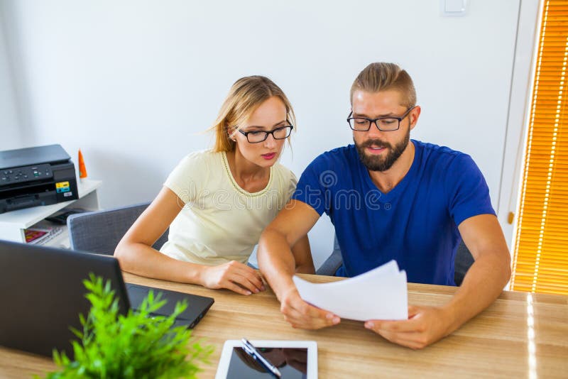 Homme d'affaires et femme d'affaires analysant quelques documents Business images libres de droits Homme d'affaires et femme d'affaires analysant quelques documents Business images libres de droits