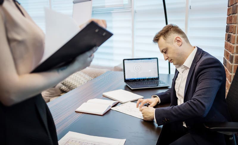 Homme d'affaires et son secrétaire auxiliaire dans son bureau Le Secre image stock Homme d'affaires et son secrétaire auxiliaire dans son bureau Le Secre image stock