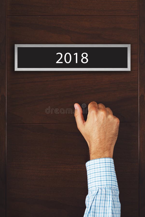 Homme d'affaires frappant sur la porte avec le numéro 2018 image libre de droits Homme d'affaires frappant sur la porte avec le numéro 2018 image libre de droits