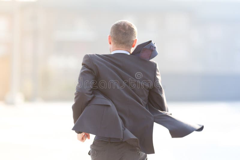 Homme d'affaires heureux courant dans la ville photo libre de droits Homme d'affaires heureux courant dans la ville photo libre de droits