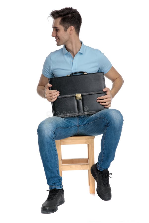 Homme d'affaires joyeux regardant au côté et tenant sa serviette image libre de droits Homme d'affaires joyeux regardant au côté et tenant sa serviette image libre de droits