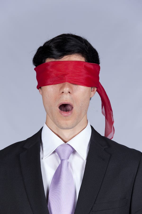 Hostage businessman with a red blindfold covering his eyes (isolated on gray). Hostage businessman with a red blindfold covering his eyes (isolated on gray)