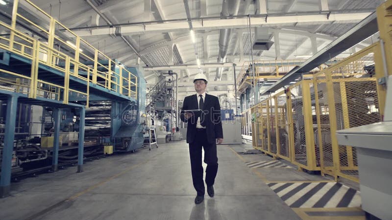 Homme d'affaires marchant par l'usine banque de vidéos