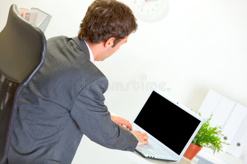 Homme d'affaires moderne travaillant sur l'ordinateur portatif image libre de droits Homme d'affaires moderne travaillant sur l'ordinateur portatif image libre de droits
