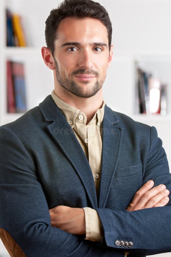 Casual businessman with arms crossed with a bookshelf behind him. Casual businessman with arms crossed with a bookshelf behind him