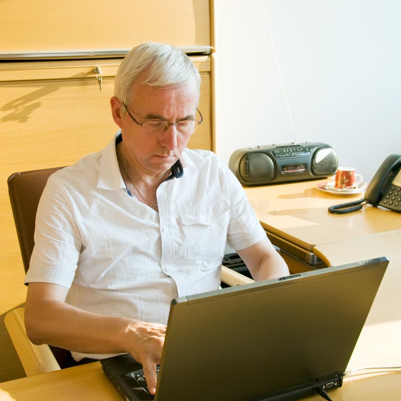 Casual businessman working at the desk with laptop. Casual businessman working at the desk with laptop