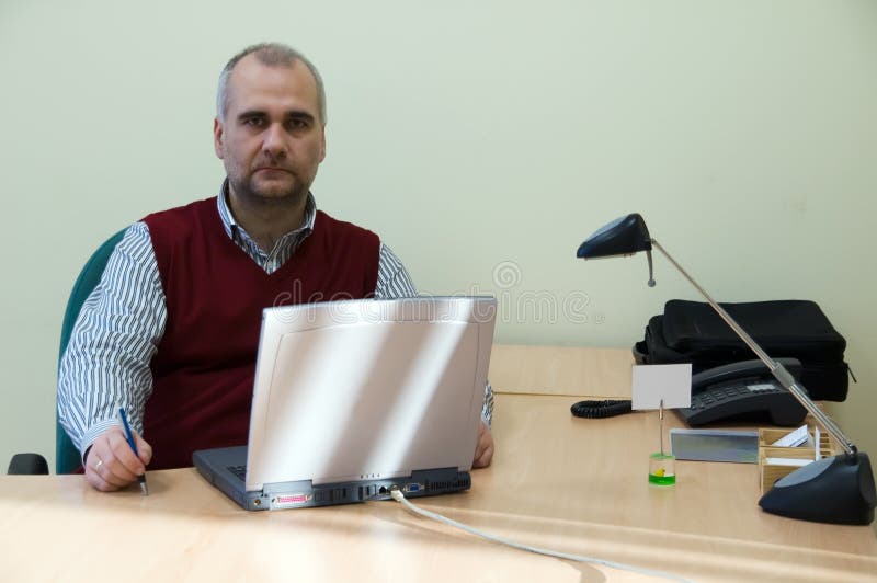 Casual businessman with laptop at his desk. Casual businessman with laptop at his desk