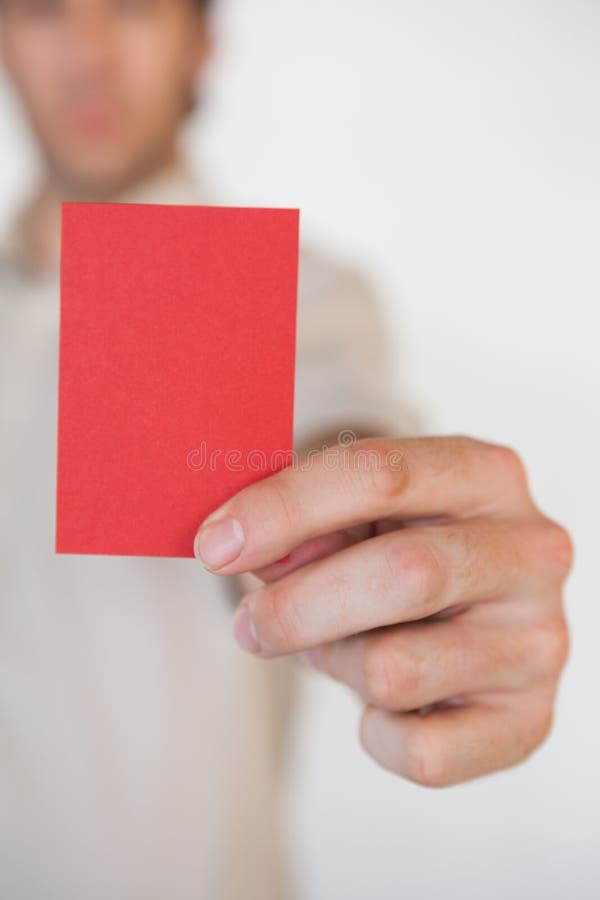 Casual businessman showing red card in the office. Casual businessman showing red card in the office