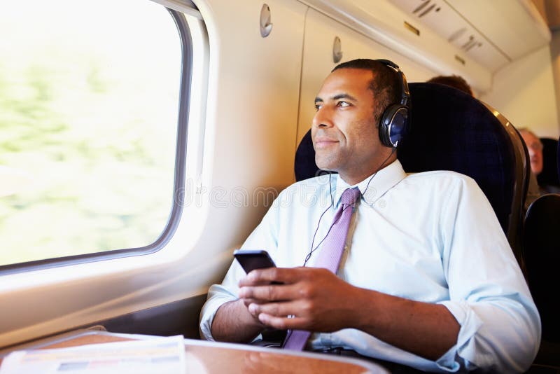 Homme d'affaires Relaxing On Train écoutant la musique Homme d'affaires Relaxing On Train écoutant la musique