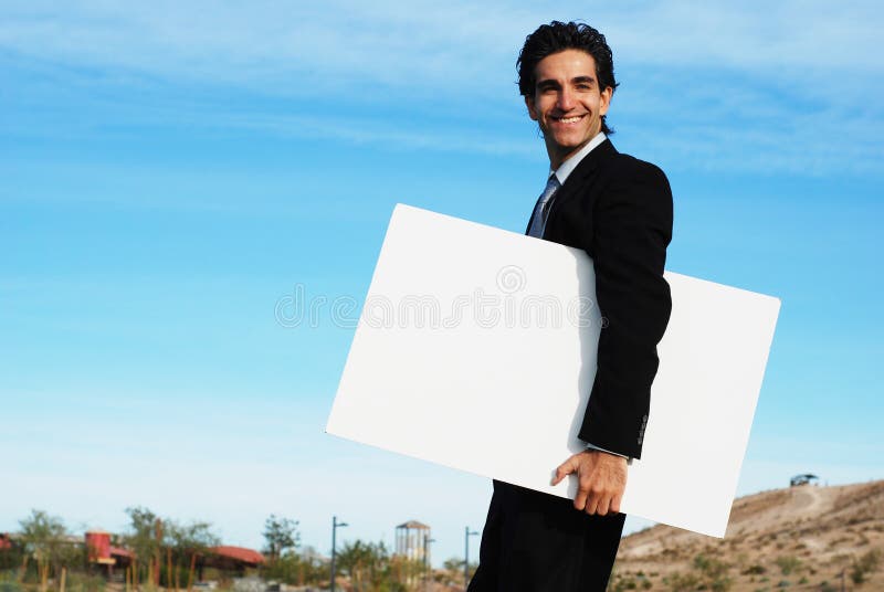Homme d'affaires retenant le panneau blanc
